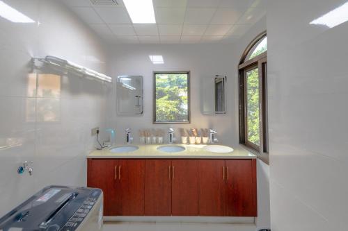a bathroom with two sinks and a window at Kaibu Courtyard Superior Apartment, Changjiang Cable Car Nanbin Road, Chongqing in Chongqing