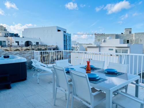 a white table and chairs on a balcony at Poseidon Court Penthouse SUPERIOR in St. Paul's Bay
