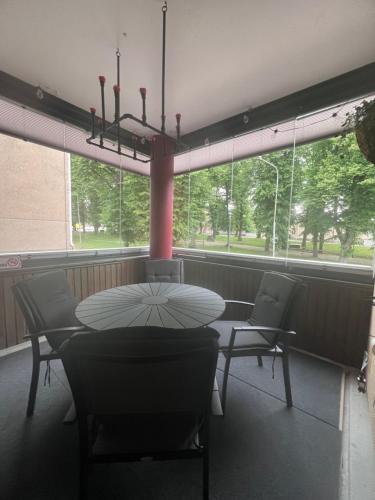 a table and chairs in a room with a large window at Loviisan Helmi 102 in Lovisa
