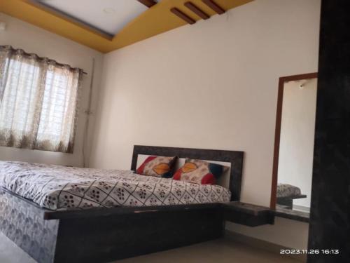 a bedroom with a bed and a mirror at Shivalaya Homestay in Nashik