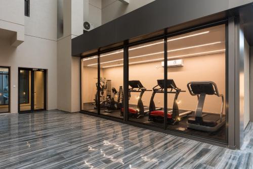a gym with a row of treadmills and ellipticals at The Code Residence - ذا كود ريزيدنس in Kuwait