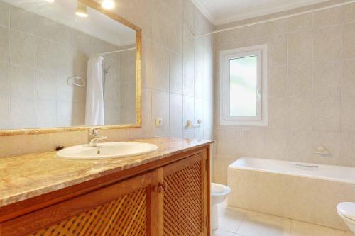 a bathroom with a sink and a tub and a mirror at Villa La Pinta in Santanyi
