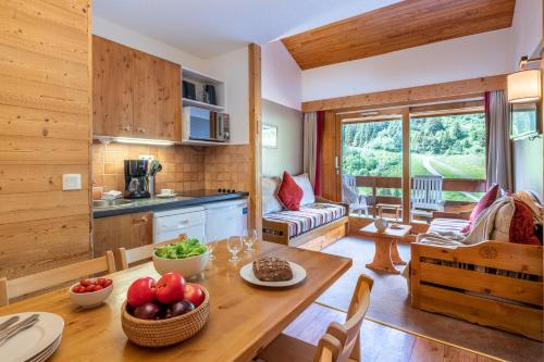 a kitchen and living room with a table with fruit on it at Résidence Pierre & Vacances Les Sentiers du Tueda in Méribel