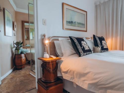 a bedroom with a bed and a lamp on a table at Kennedys Beach Villa in Hermanus