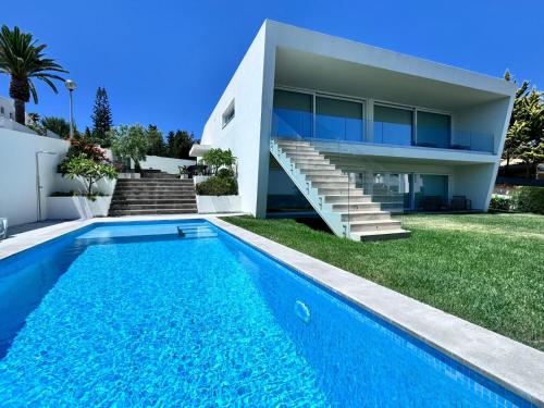 a villa with a swimming pool in front of a house at Luz Vila in Luz