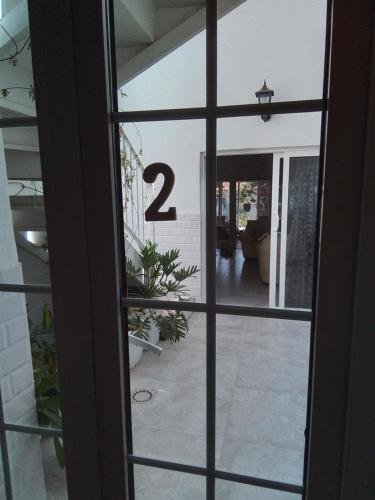 a view through a glass door with the number two at Alba 2 apartamento y Alba 3 habitación con baño in Puerto del Rosario