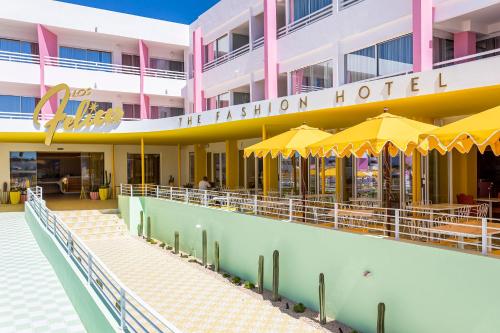 a hotel with yellow umbrellas in front of it at Los Felices Ibiza in San Antonio Bay