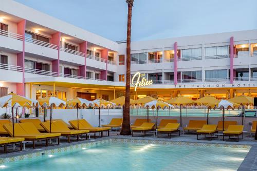 a hotel with a swimming pool and chairs and a building at Los Felices Ibiza in San Antonio Bay