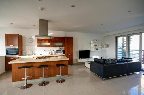 una cucina e un soggiorno con un divano blu di Old Mint Penthouse a La Valletta