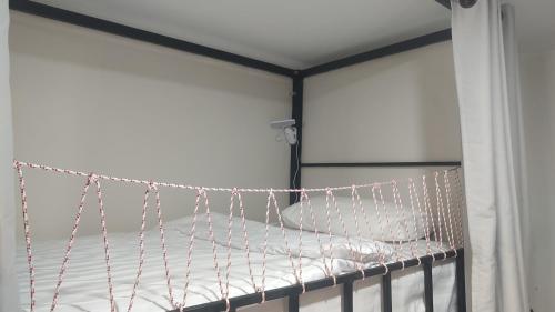a bed in a room with chains on it at Bambus Restaurant, Bar & Hostel in Patong Beach