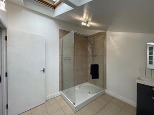 a bathroom with a shower with a glass door at Tovey Lodge in Hassocks