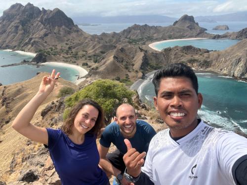 a group of three people sitting on top of a mountain at Jhuna Komodo Homestay in Komodo