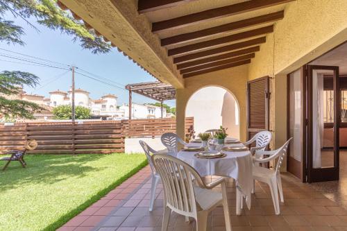 un tavolo e delle sedie sul patio di una casa di Apart-rent Casa con jardín Pani 0081 a Empuriabrava