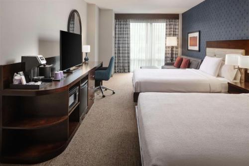 a hotel room with two beds and a desk with a television at Hilton Garden Inn Washington DC/Georgetown Area in Washington