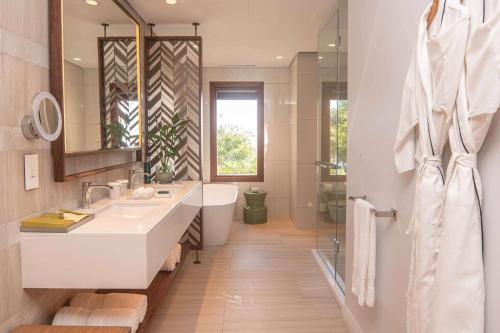 a bathroom with a sink and a toilet and a mirror at Hilton Mauritius Resort & Spa in Flic-en-Flac