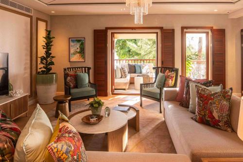 a living room with a couch and a table and chairs at Hilton Mauritius Resort & Spa in Flic-en-Flac