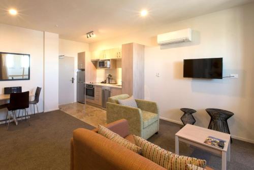 a living room with a couch and a table at Ramada Suites by Wyndham Christchurch City in Christchurch