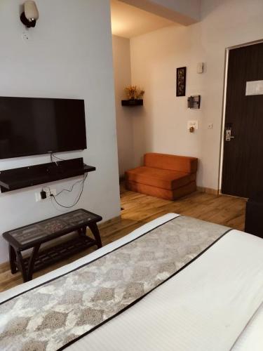 a bedroom with a bed and a flat screen tv at Pearl suites at Omaxe entrenity in Vrindāvan