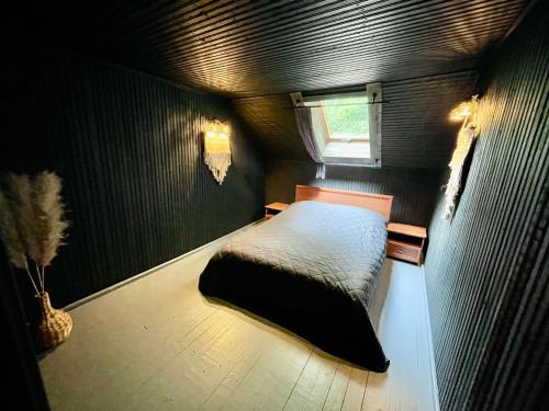 a small bedroom with a bed and a window at Sodyba Mėnulio Slėnis in Padubysys