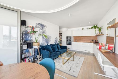 un salon avec un canapé bleu et une table dans l'établissement Veeve - The Transforming Terrace, à Paris