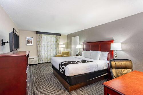 a hotel room with a bed and a desk at La Quinta by Wyndham Indianapolis South in Indianapolis