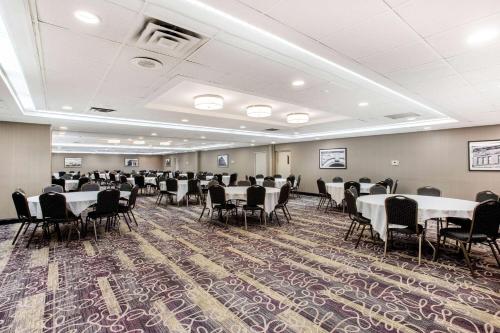 a conference room with tables and chairs in it at La Quinta by Wyndham Indianapolis South in Indianapolis