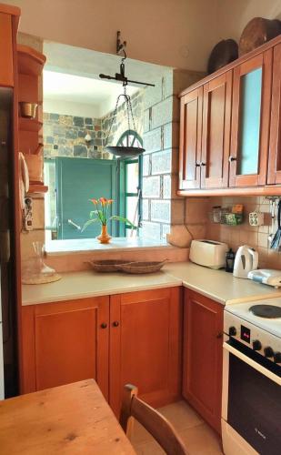 a kitchen with wooden cabinets and a table and a window at Refoulo Tower in Poliána