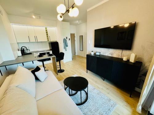 a living room with a white couch and a desk at H ApartStudio Targowa 4 in Ełk