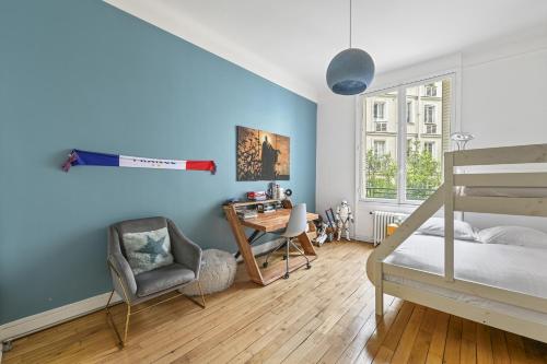 - une chambre avec des murs bleus, un lit et un bureau dans l'établissement Veeve - Gardenside Glamour, à Paris