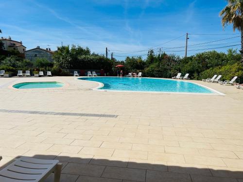 une grande piscine avec des chaises dans l'établissement Joli appartement - Terrasse vue mer, à Mandelieu-la-Napoule