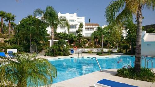 a large swimming pool with palm trees and a building at Casa lagoon & pool, Alcazaba by Casa del sol HR in Casares