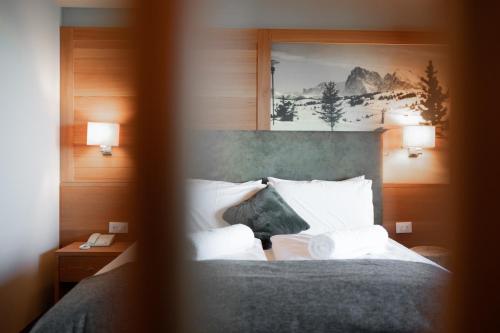 a bedroom with a bed with two pillows at Berghotel Zorzi in Alpe di Siusi