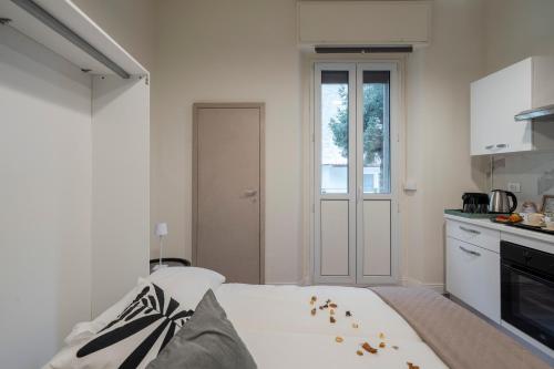 a white room with a bed and a kitchen at Loreto Prestige - Parking Free & Bulb Gym in Milan