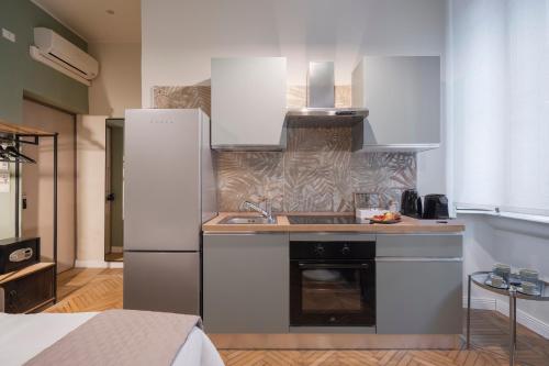 a kitchen with a white refrigerator and a sink at Loreto Prestige - Parking Free & Bulb Gym in Milan