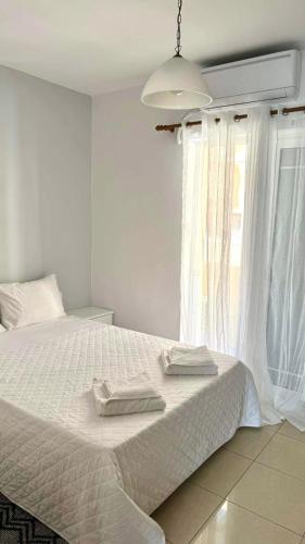 a bedroom with a white bed with two towels on it at AQUALIA Apartment 2 in Karpathos Town