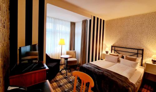 a hotel room with a bed and a television at Hotel Schieferhof - GlasLUST in Neuhaus am Rennweg