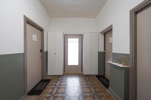 a hallway with white walls and a door with a window at Loreto Prestige - Parking Free & Bulb Gym in Milan