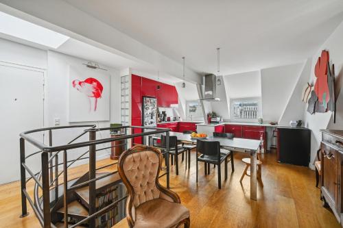 une cuisine avec des armoires rouges et une table et des chaises dans l'établissement Veeve - The Spiral Centrepiece, à Paris