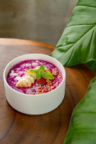 a white bowl of food on a wooden table at Arpana Luxury Private Pool Villas in Jimbaran