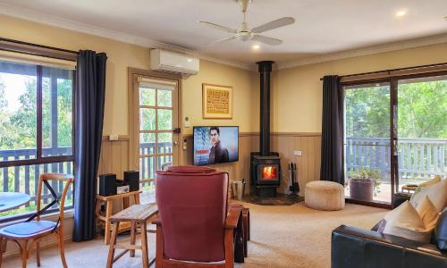 a living room with a fireplace and a tv at Tarilta Cottage in Hepburn Springs