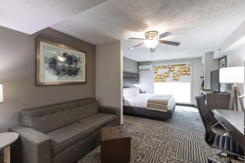 a hotel room with a couch and a bed at Country Inn & Suites by Radisson, Lake Norman Huntersville, NC in Huntersville
