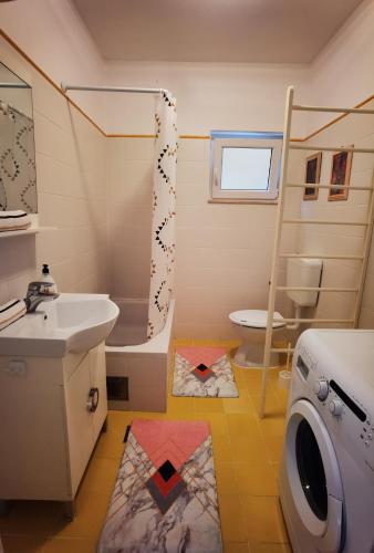 a bathroom with a sink and a washing machine at Apartment Loza Senj in Senj