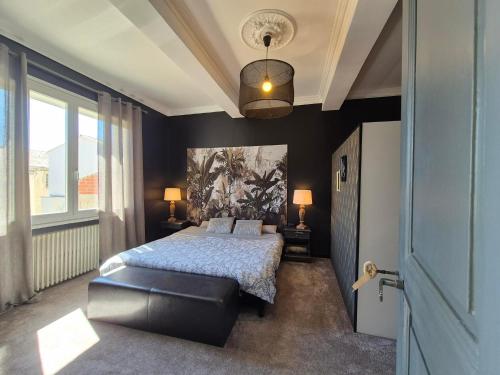 a bedroom with a bed and a large window at Maison de Maître L Oustal des Halles avec salle de cinéma, billard & Jacuzzi in Castelnaudary