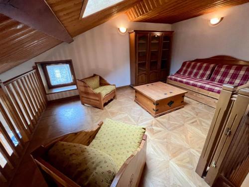 Cette chambre mansardée comprend deux lits et une chaise. dans l'établissement Appartement 14 personnes avec balcon et terrasse au cœur de Val Cenis Lanslebourg, proche commerces - FR-1-508-258, à Val Cenis