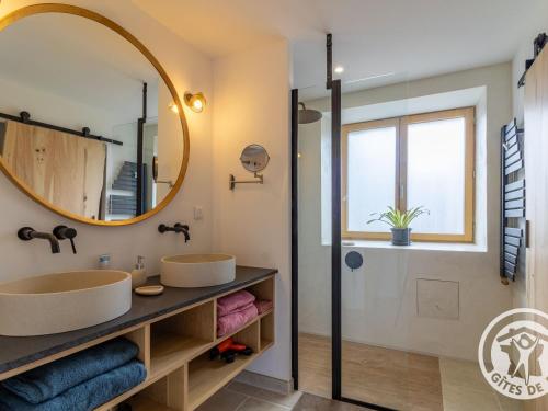 ein Badezimmer mit zwei Waschbecken und einem Spiegel in der Unterkunft Chambre d'hôtes avec piscine et petit-déjeuner proche d'Angers - FR-1-622-84 in La Rochefoulques