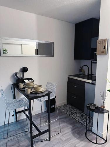 une cuisine avec une table et des chaises dans une pièce dans l'établissement Les Nuits d'Orient - Proche de Disneyland Paris & Paris Centre, à Bussy-Saint-Georges