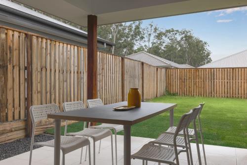 a table and chairs on a patio with a fence at Brand new 4BR Family-friendly house WIFI Garage in Jimboomba