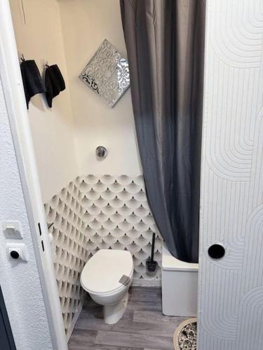 La salle de bains est pourvue de toilettes et d'un rideau de douche noir. dans l'établissement Les Nuits d'Orient - Proche de Disneyland Paris & Paris Centre, à Bussy-Saint-Georges