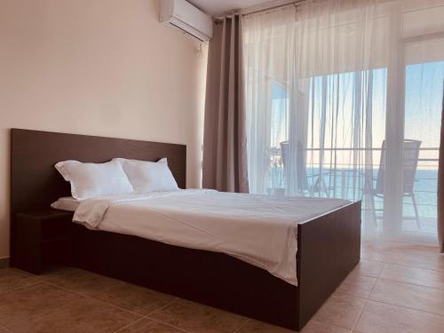 a bedroom with a bed and a large window at Lemon in Costinesti