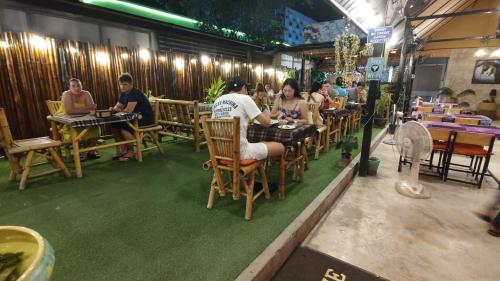 a group of people sitting at tables in a restaurant at Bambus Restaurant, Bar & Glamping in Patong Beach